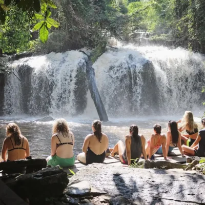 Travelers sitting by a Chiang Mai waterfall enjoying the view.