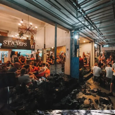 Guests relaxing in the social common area at Stamps Backpackers hostel.